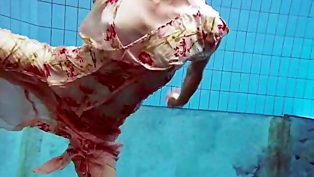 Slender teen goes for a swim in her pretty dress