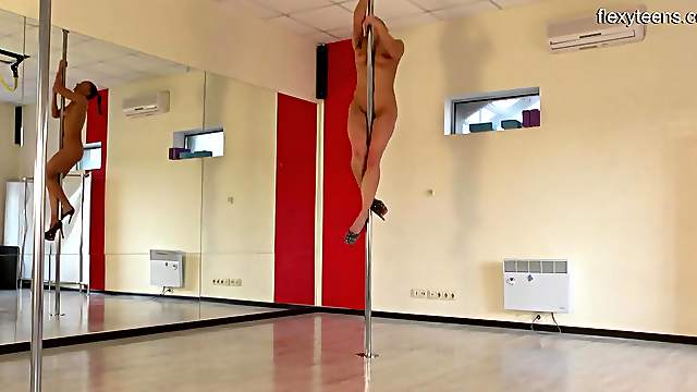 Naked high heeled teen works a stripper pole