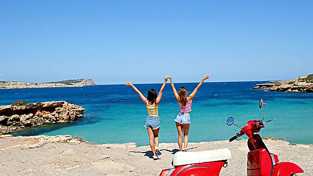 Two hot girls have fun on the beach with their bikinis on