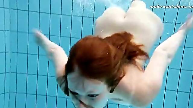 Redhead teen goes swimming in her prom dress