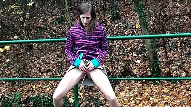 Teen lifts her skirt to pee in the grass